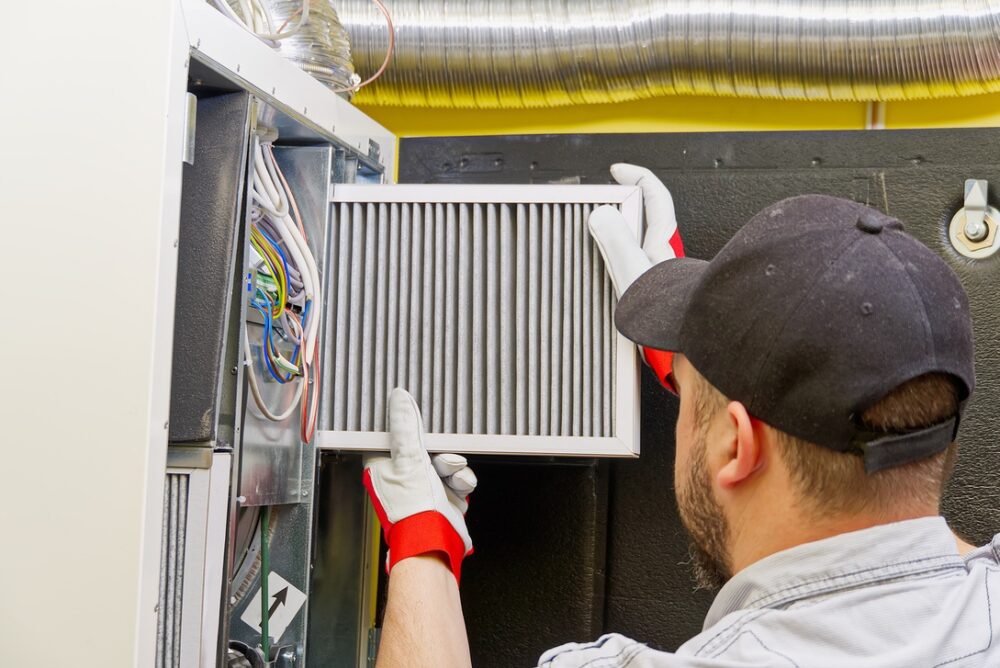 Man inspecting air filter for residential heat pump
