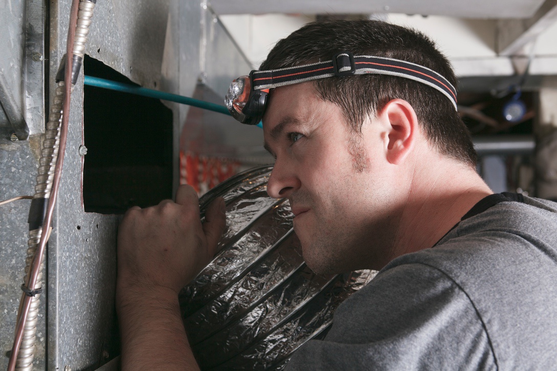 HVAC technician inspecting ductwork before cleaning in Nebraska home