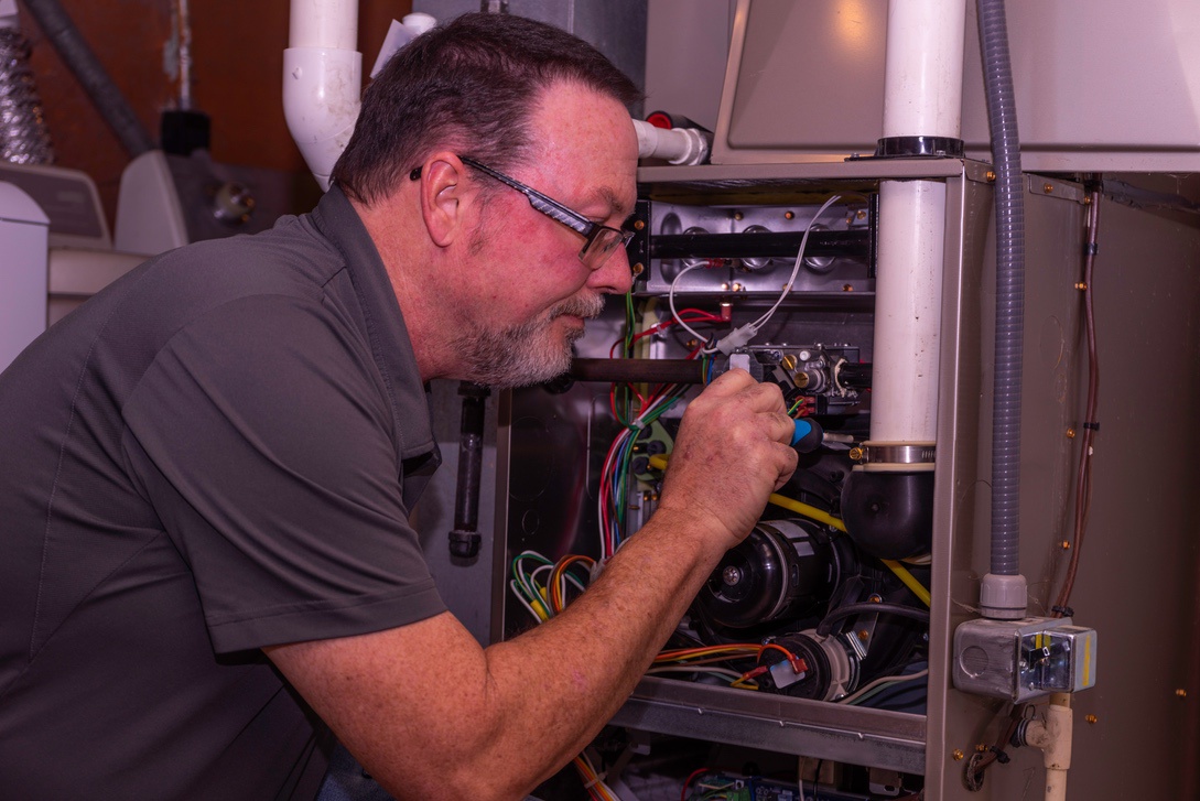 HVAC technician performing furnace tune-up for Nebraska home before winter