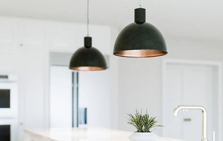 Two light fixtures hanging above a kitchen