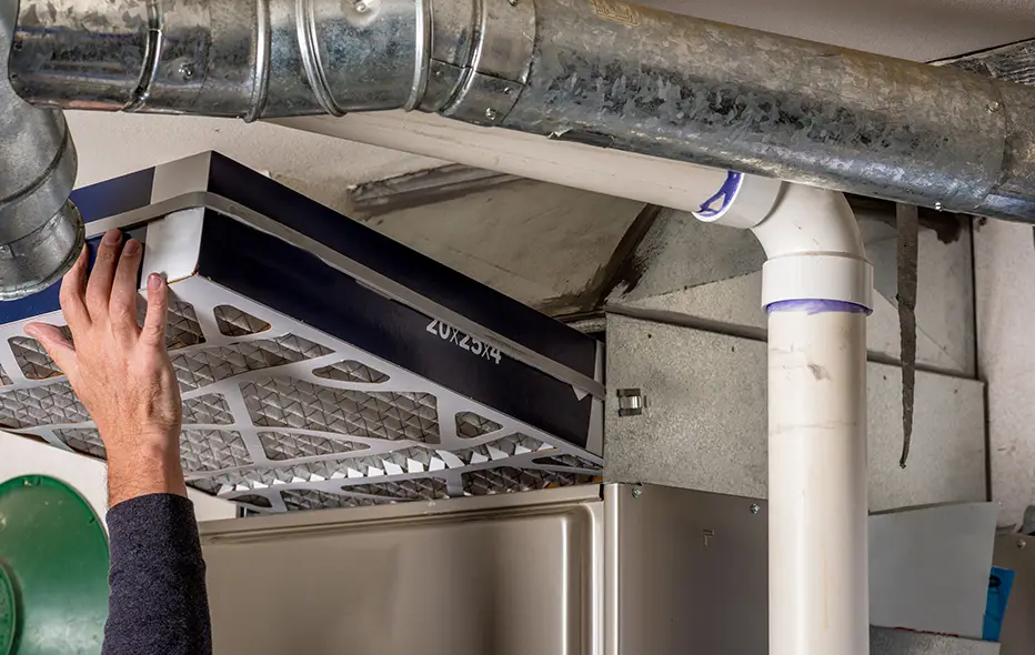 HVAC technician replacing a furnace filter